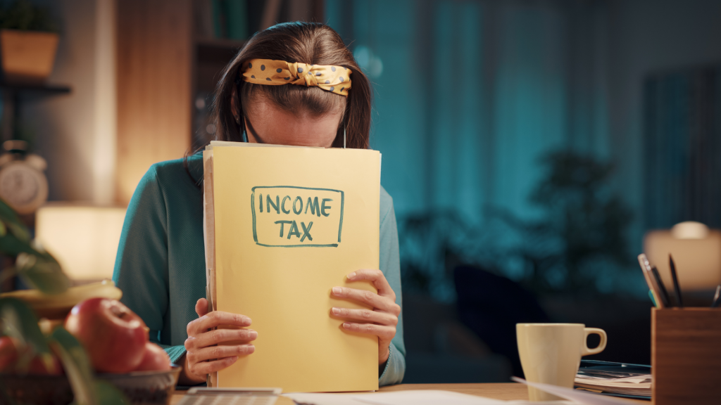 Relógio e calculadora sobre papéis fiscais, representando custos ocultos.