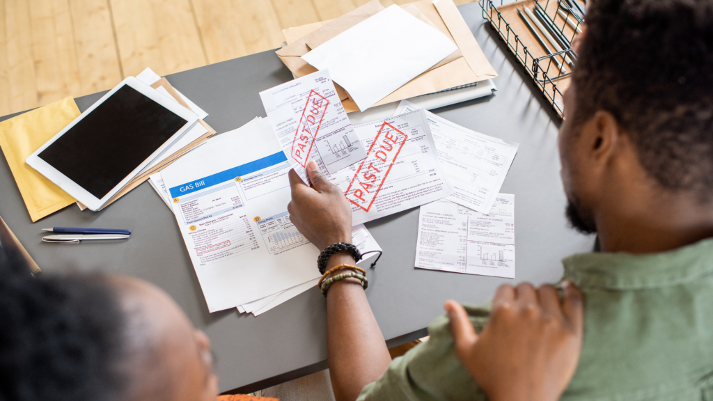 Documentos fiscais carimbados e contas organizadas sobre a mesa.